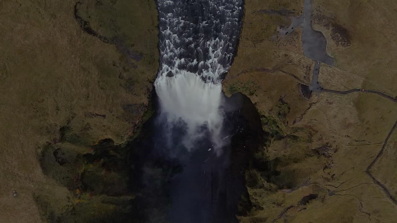 drone sobre los acantilados de la cascada skógafoss que muestra los senderos del paisaje islandés