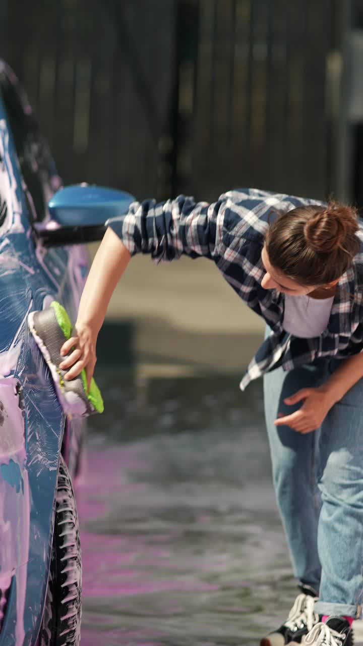 una mujer lavando un coche.
