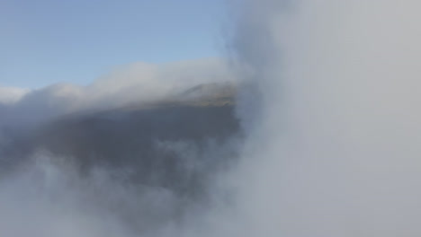 fly through white clouds moving over the slopes of haleakala volcano on maui at daylight