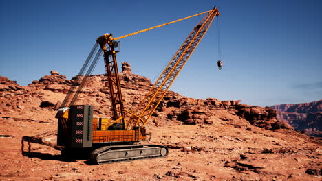 a large orange crane sits in a desert canyon