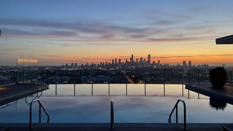 stunning sunset over a city skyline reflected in a pool: a captivating view from a modern rooftop infinity pool at dusk