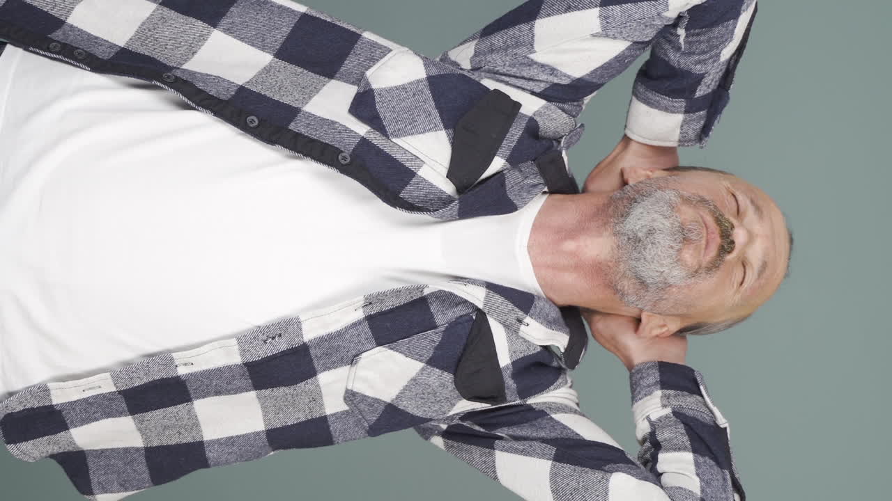 Vertical video of Old man looking depressed at camera.