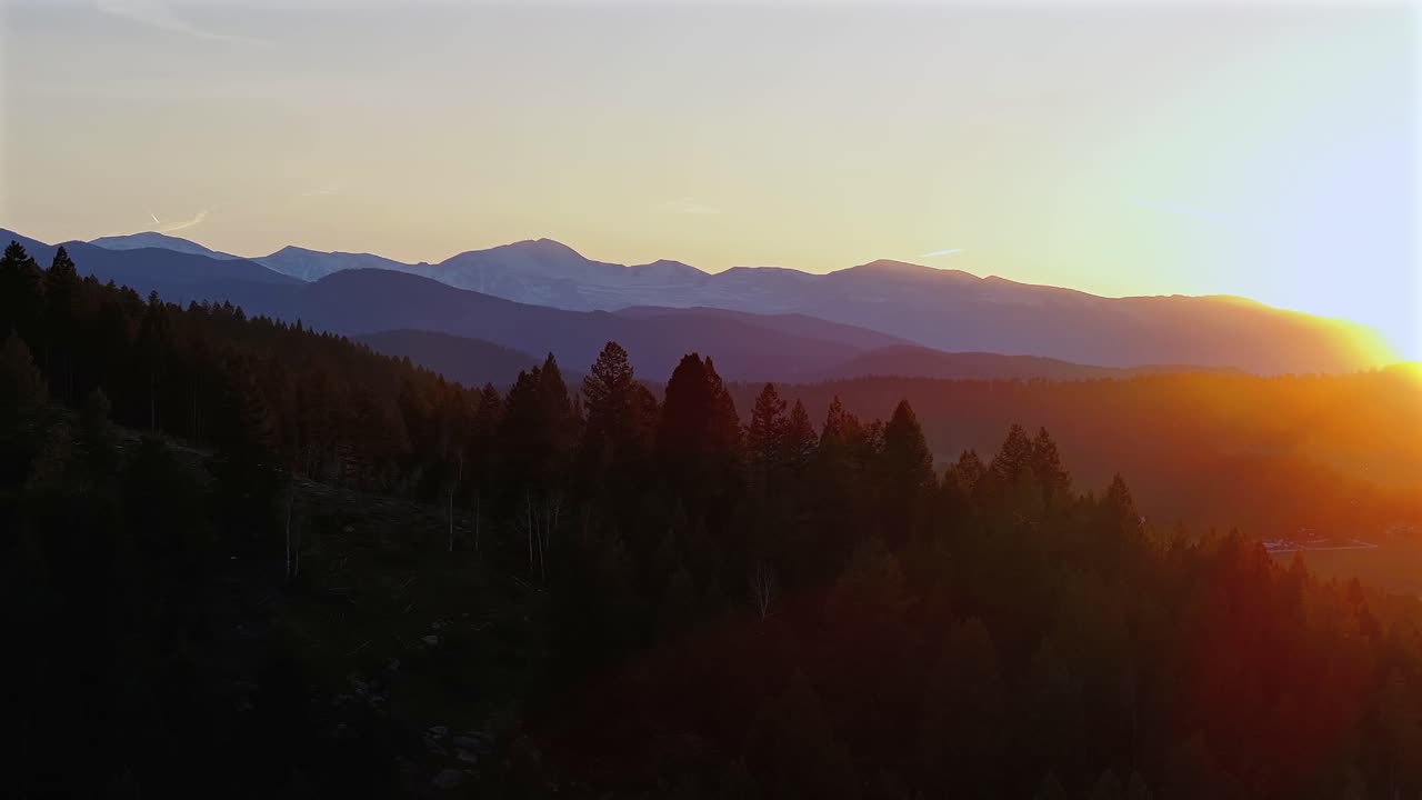 Mount Blue Sky front range Mt Evans peak aerial drone Evergreen Colorado scenic bypass golden hour sunset sun flare yellow sky Rocky Mountains layers Arapaho National Forest spring summer upwards