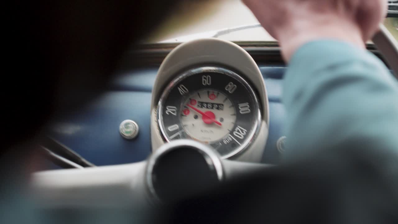 Close-up of a vintage Fiat car's speedometer while driving. Classic car, road trip, nostalgia concept.