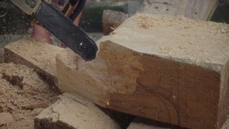 Hombre-Irreconocible-Cortando-Con-Una-Motosierra-Un-Bloque-De-Madera.