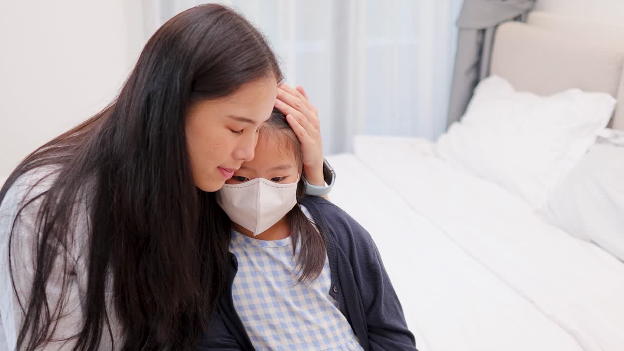 明るい寝室で、マスクを着けた母親が病気の娘を慰めている様子。自然で柔らかな光が差し込む。