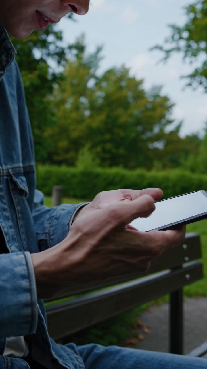 Close-up, low-angle shot of a person using a smartphone outdoors
