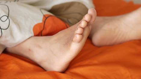 feet sticking out of bed linens