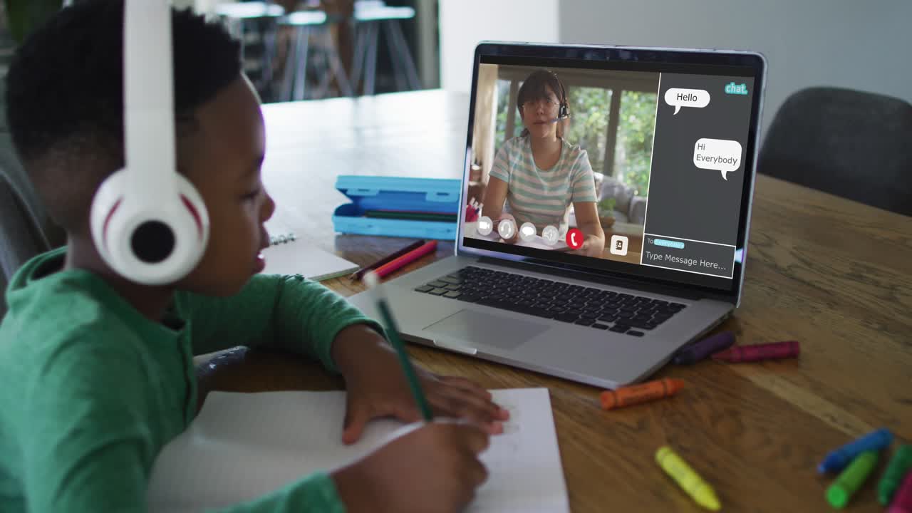 Schoolboy using laptop for online lesson at home, with his colleague and web chat on screen
