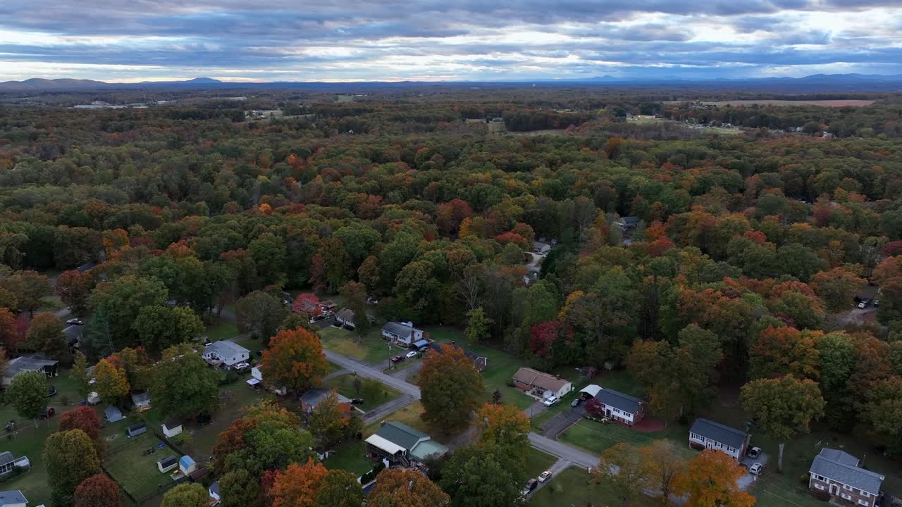Housing and residential of American between multi-colored trees in USA. Cloudy morning in America with houses and homes. Aerial wide shot. Serene atmosphere landscape: