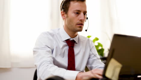 businessman office worker taking note with pen while talking in video conference using headphone in call center customer care