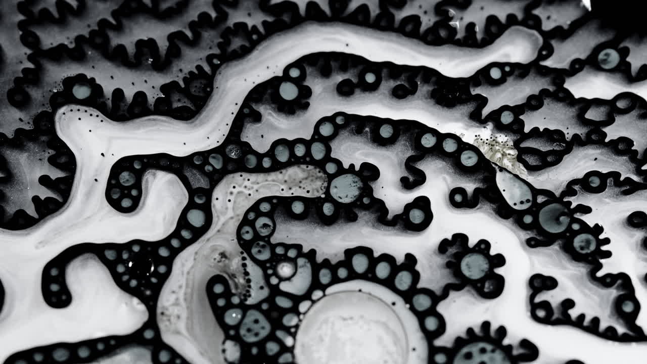 Abstract close-up of liquid mixing, featuring unique black and white patterns