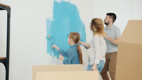 family painting a wall in new home
