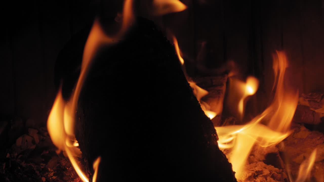 나무 통나무에 있는 벽난로에서 타는 불꽃