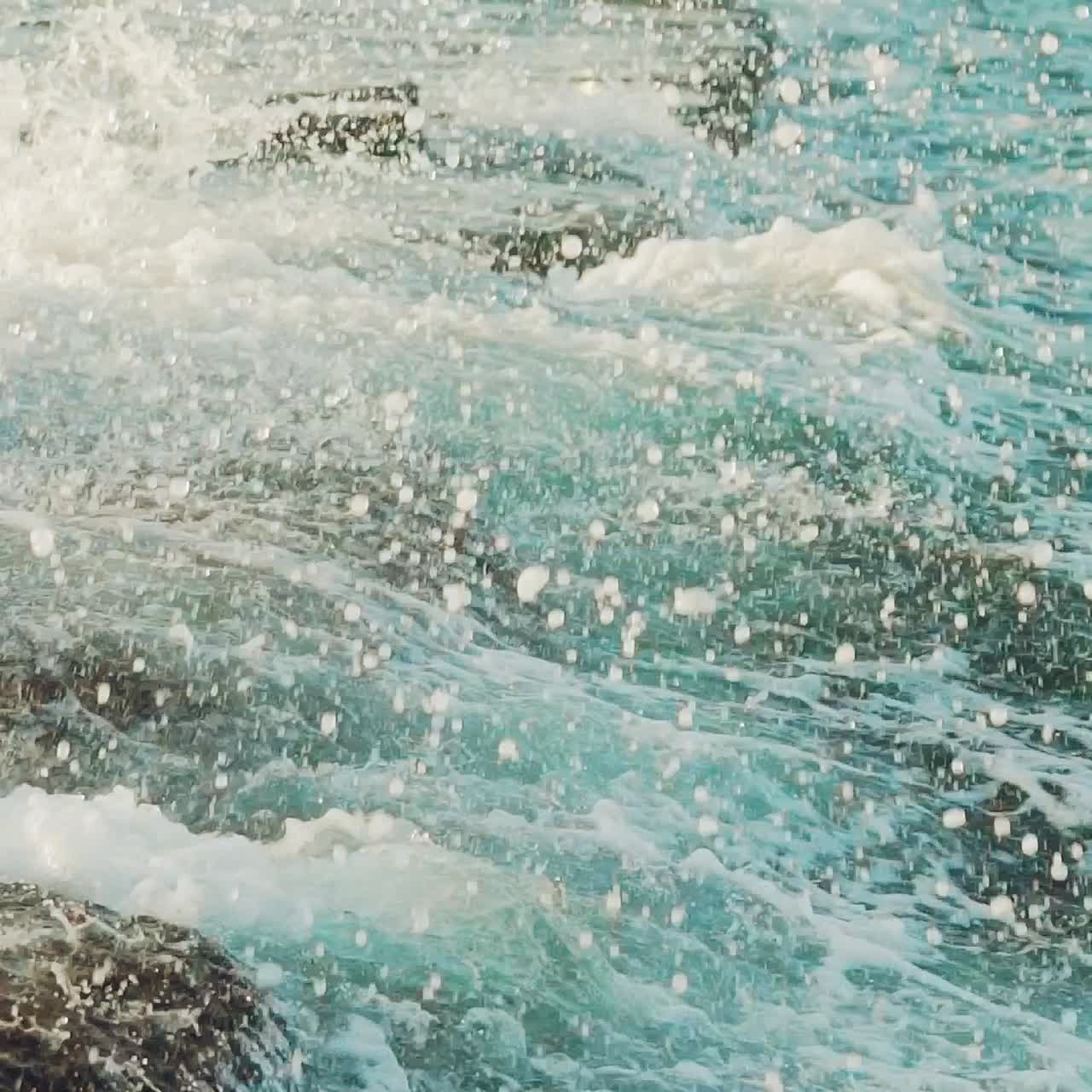 Waves are beating on the underwater reefs off the coast. Spray of water. Slow motion