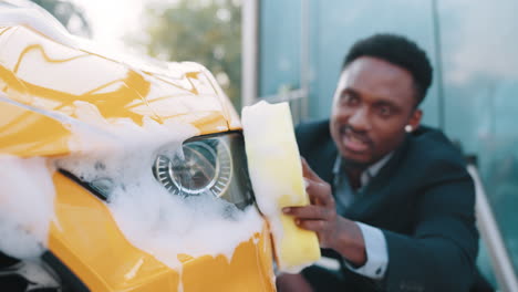 man washing a yellow car