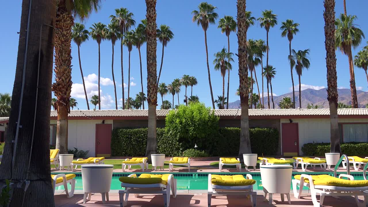 팜스프링스 또는 캘리포니아 로스앤젤레스에 있는 고전적인 복고풍 모텔의 설정 샷은 수영장과 데크 의자 2입니다.