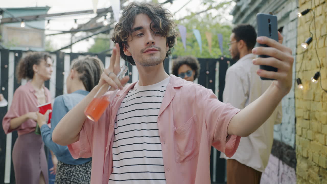 Young Man Taking Selfie at a Backyard Party
