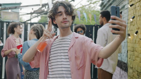 young man taking selfie at a backyard party