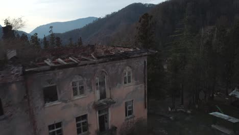 aerial view of a ruined building in a mountainous forest