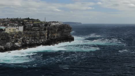 Breathtaking-view-over-ocean-with-waves-crashing-on-rocky-cliff-coast,-Bondi-Beach-in-Australia