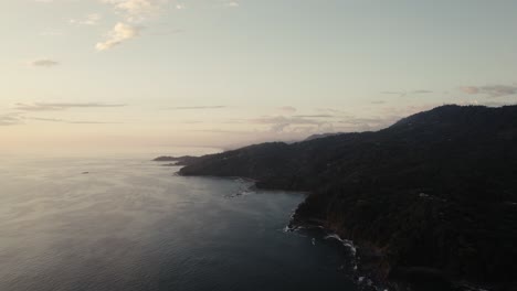 drone over wild jungle coastline during sunset in costa rica