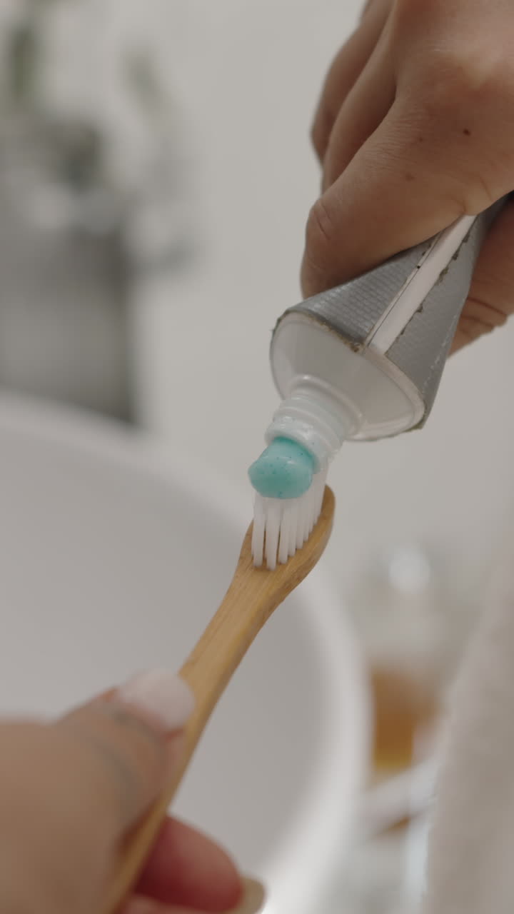 Hands of Woman Squeezing out Toothpaste on Toothbrush