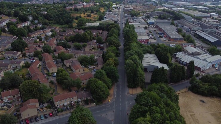 Ripresa aerea con drone che si inclina verso l'alto da una vista a volo d'uccello di una strada per rivelare Burngreave, Sheffield, Inghilterra in una giornata di sole con nuvole sparse. Quartiere residenziale nel South Yorkshire