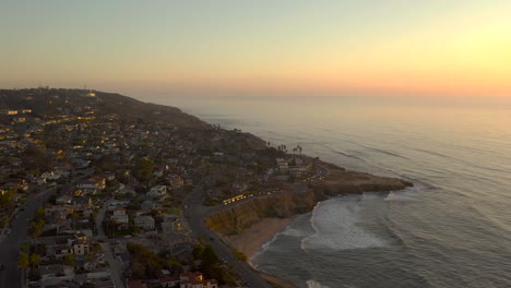 drone flying over scenic sunset cliffs in san diego, california at sunset