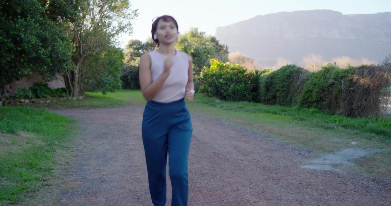 Woman starting run on gravel path, jogging toward camera, slowing, stopping, breathing, recovering