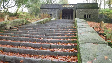 Stone-staircase-covered-in-moss-and-leaves-Rivington-terraced-garden-woodland-forest-wilderness-dolly-left