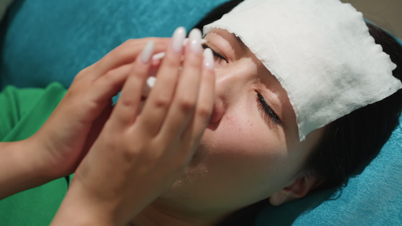 이마를 식히는 여성, 가정에서 부드럽게 의료 치료를 받는 여성, 집에서 차분하게 보살핌을 받는 여성의 클로즈업, 냉찜질과 지지하는 손길로 치유되는 여성의 친밀한 장면