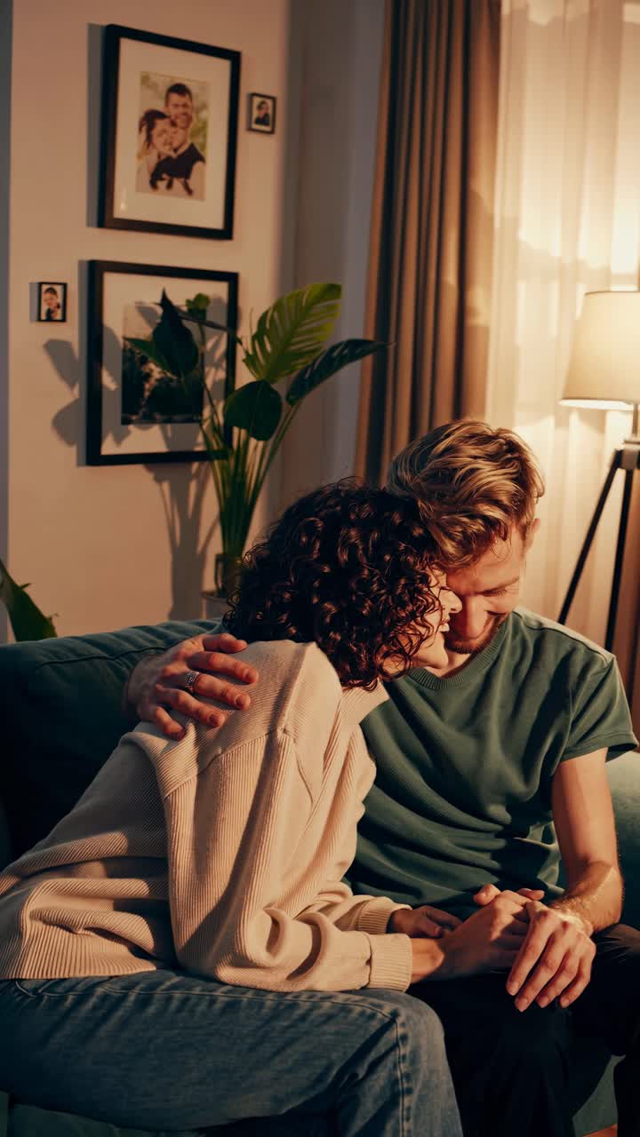 A cozy, intimate video scene of a couple on a sofa, captured from a side angle