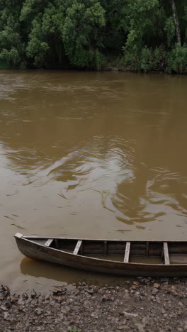 old wooden canoe on a riverbank