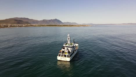 Marine-research-motor-vessel-operating-off-the-coast-with-mountains-on-a-calm-day