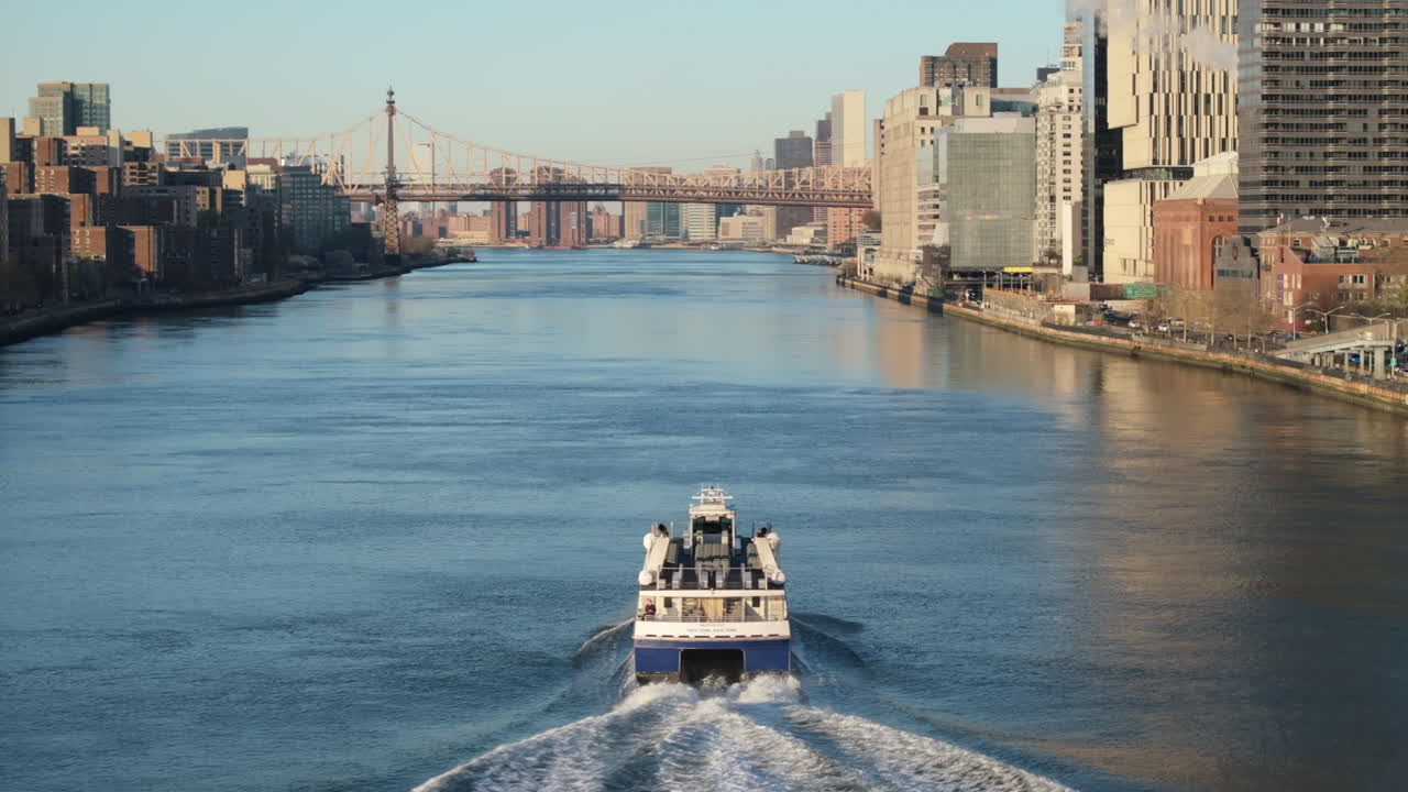 Aerial view of a ferry on New York City's East River. Shot at sunrise