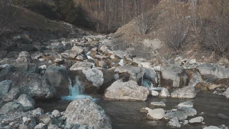 crystal-clear water gracefully cascades over rugged rocks in a tranquil mountain stream near walenstadt, switzerland. the gentle flow creates a soothing, rhythmic motion, enhancing the landscape.