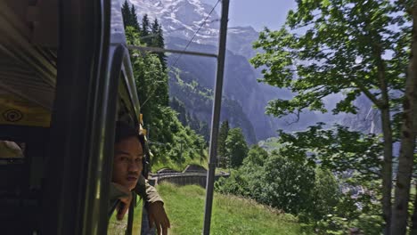 paseo panorámico en tren en la ventana de la montaña del valle de los alpes con un hombre mirando desde la ventana, lauterbrunnen suiza-1