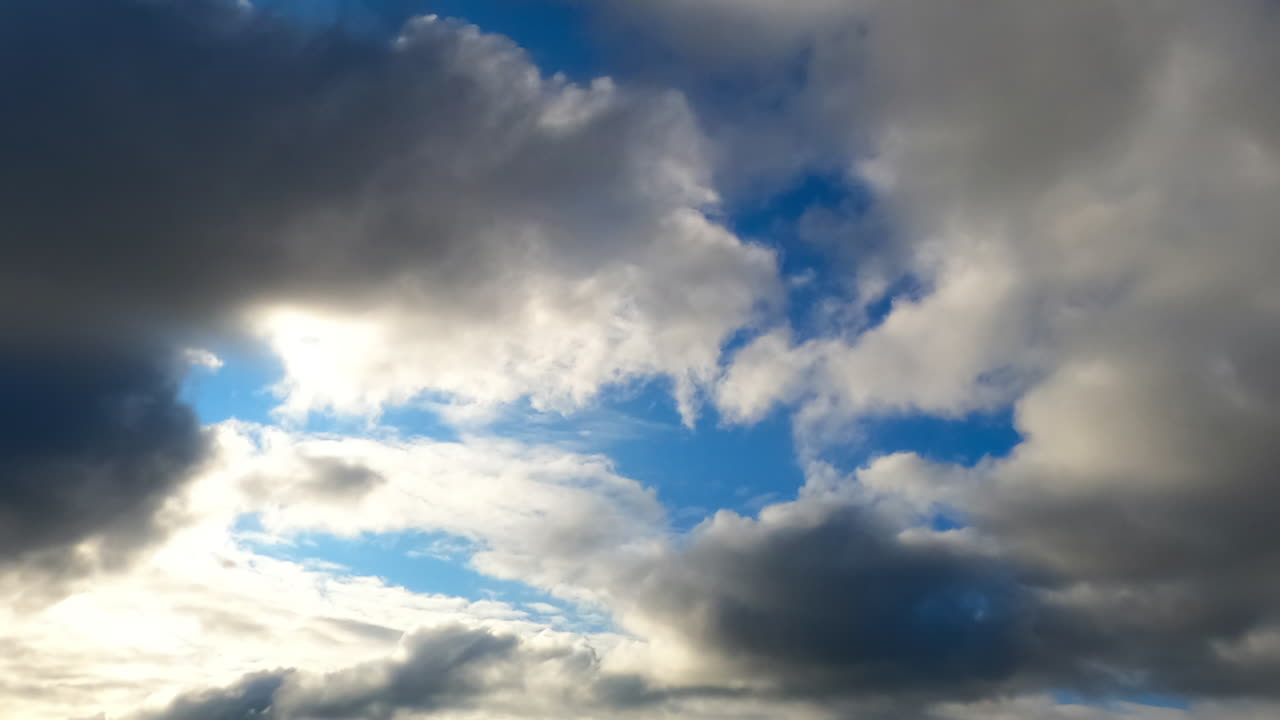 Clouds shifting in timelapse. Clouds move dynamically across the sky, showcasing varying formations and shades during a tranquil period