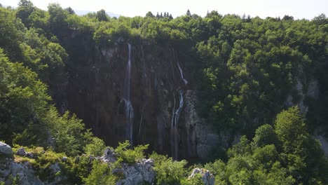 Vista-Del-Hermoso-Parque-Nacional-De-Los-Lagos-De-Plitvice-Con-Muchas-Plantas-Verdes-Y-Hermosos-Lagos-Y-Cascadas-Vuelo-Con-Drones