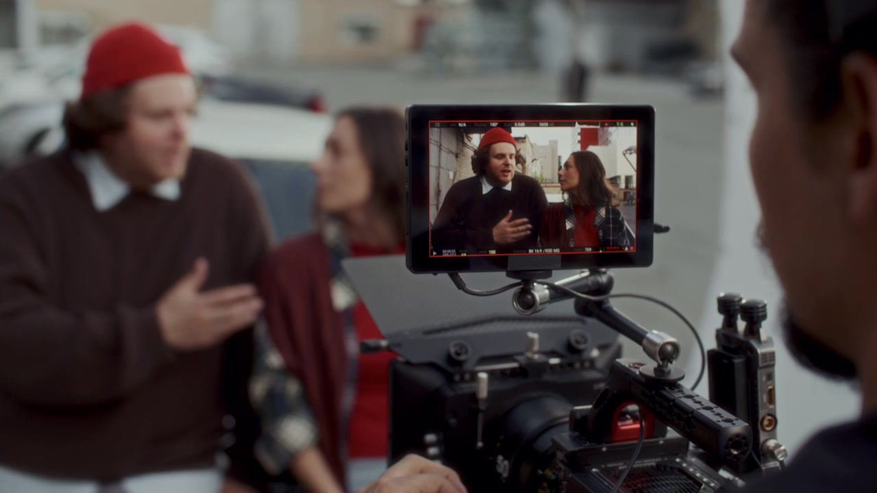 Cinematographer Filming Scene with Actors on Outdoor Movie Set
