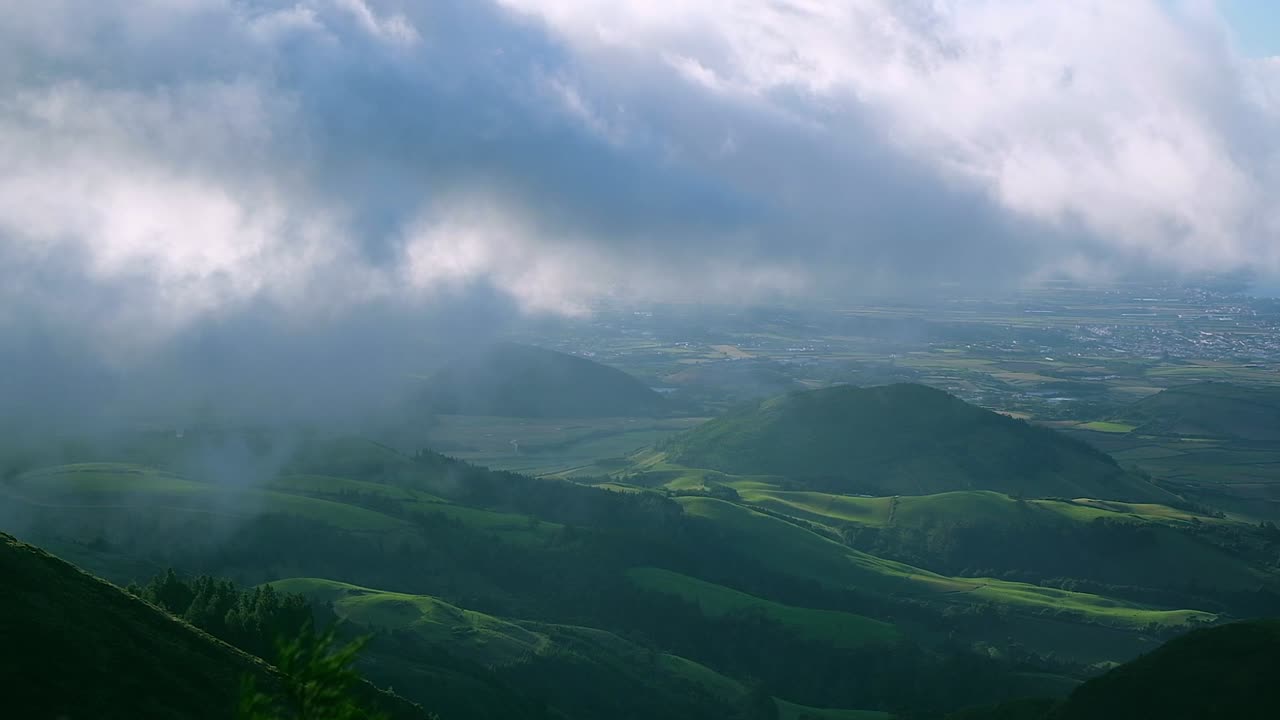 una toma cinematográfica dramática con las nubes cubriendo las hermosas colinas verdes de la isla de azores