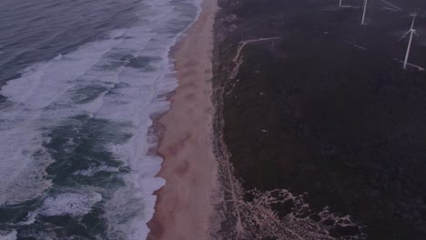 Wide-shot-of-famous-Praia-do-Norte-with-no-people-during-sunrise,-aerial