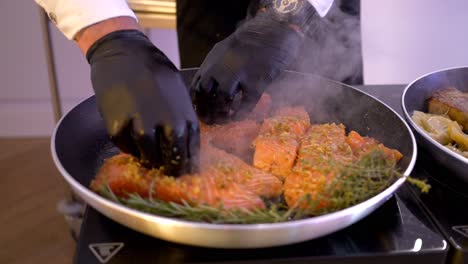 Live-cooking,-chef-adds-rosemary-to-salmon-on-the-pan