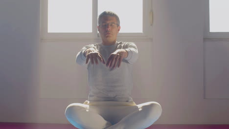 Man-sitting-in-lotus-position-and-meditating-with-closed-eyes