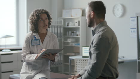 una doctora hace preguntas al paciente durante la cita médica