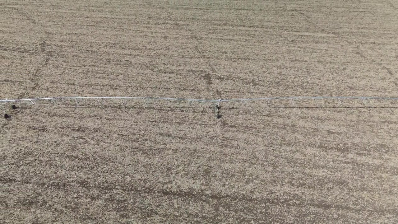 Veduta aerea di un sistema di irrigazione a perno centrale che attraversa un campo agricolo arido vicino a Debrecen, in Ungheria, che mette in risalto la gestione idrica estiva in un paesaggio rurale