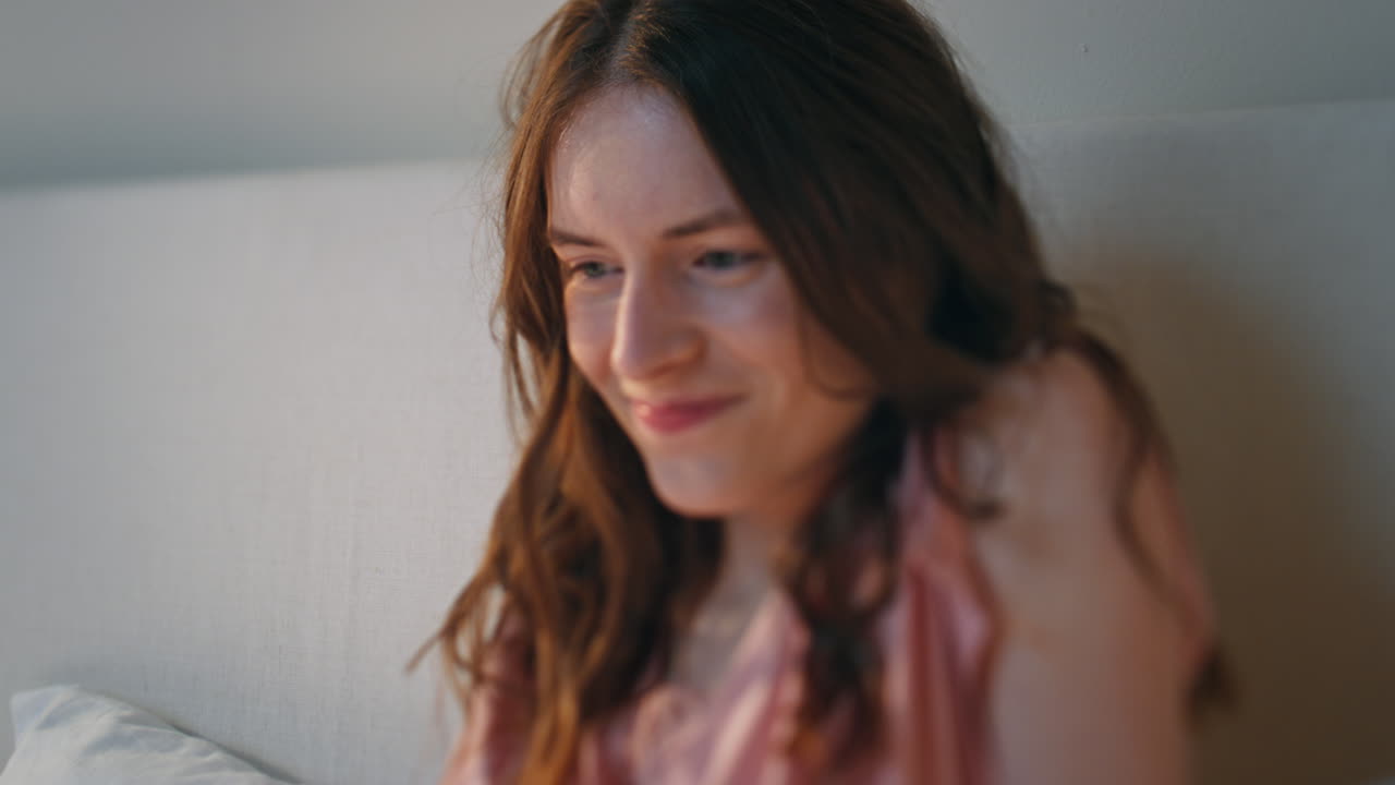 침대에서 휴식을 취하는 행복한 여성. 아침 일찍을 즐기는 기쁜 깨어있는 소녀