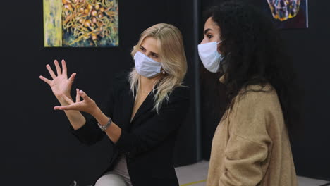 women discussing art at an exhibition