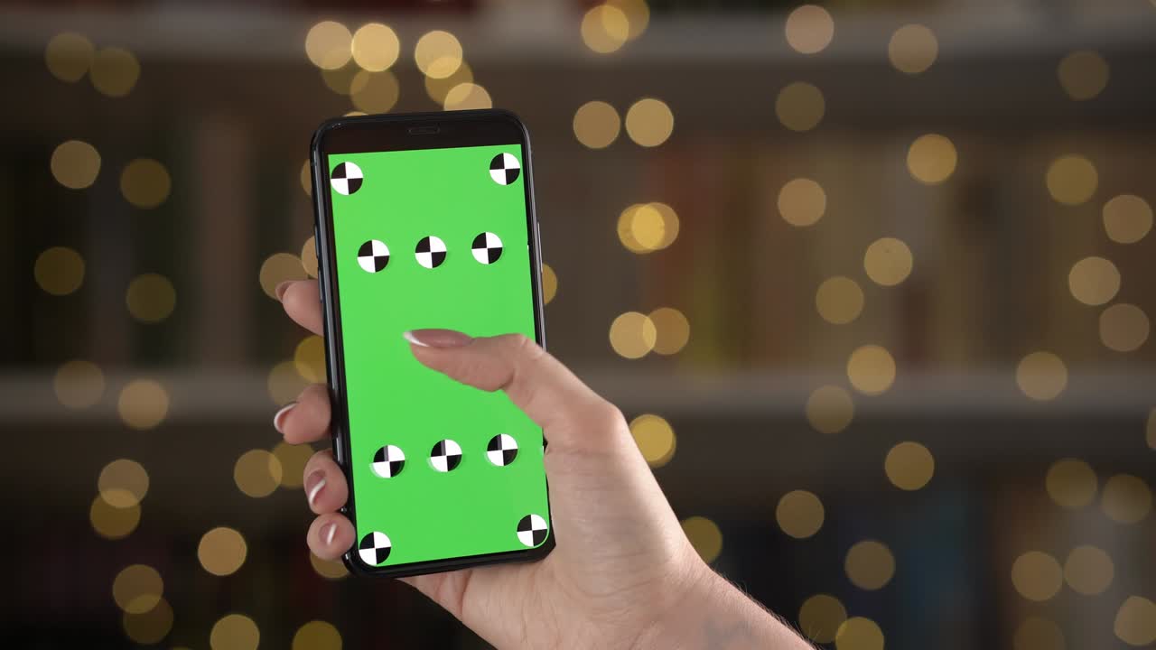 보케 배경에 있는 여성 손의 추적 포인트와 함께 스마트폰의 클로즈업 뷰